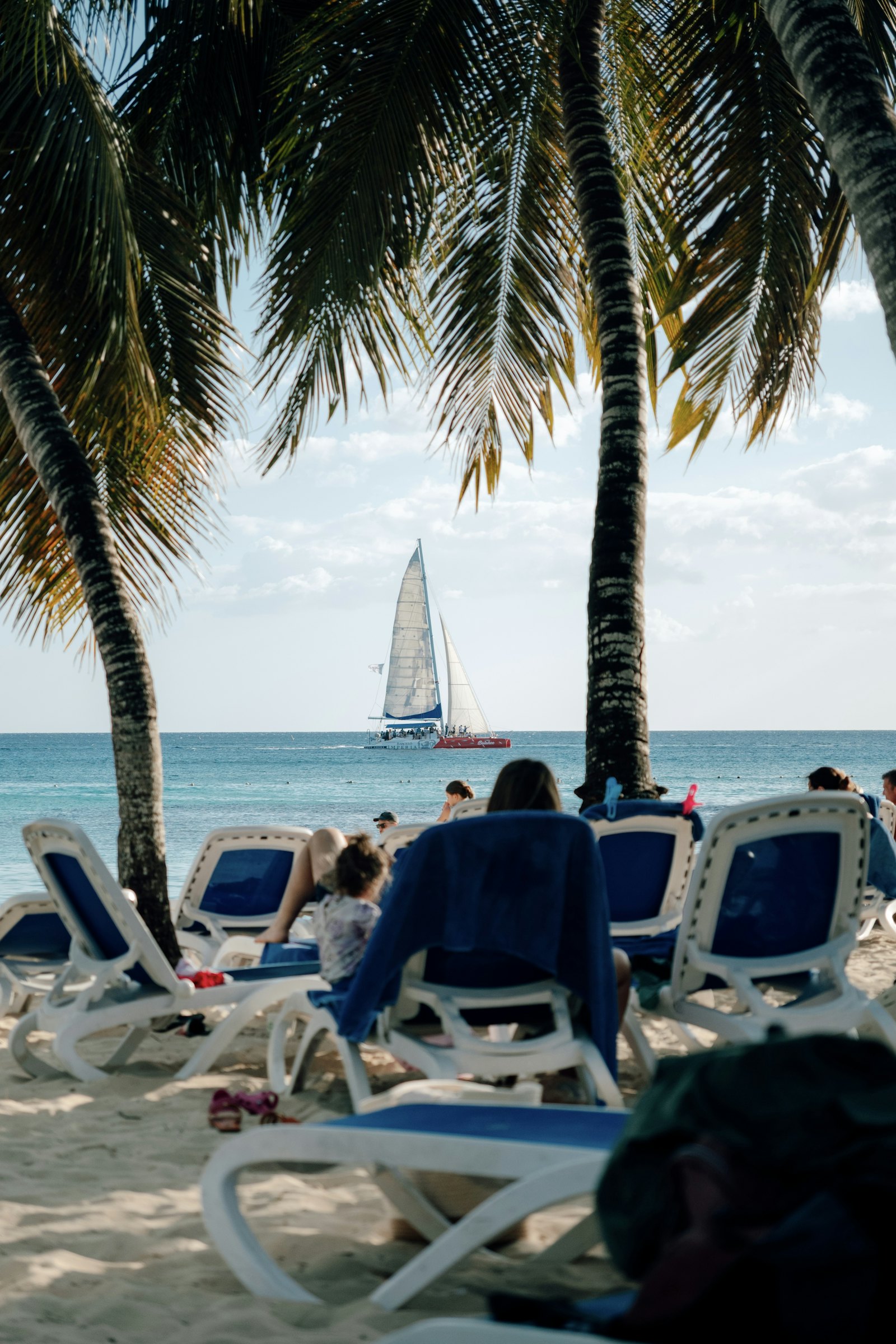 Velero visto desde una playa tropical